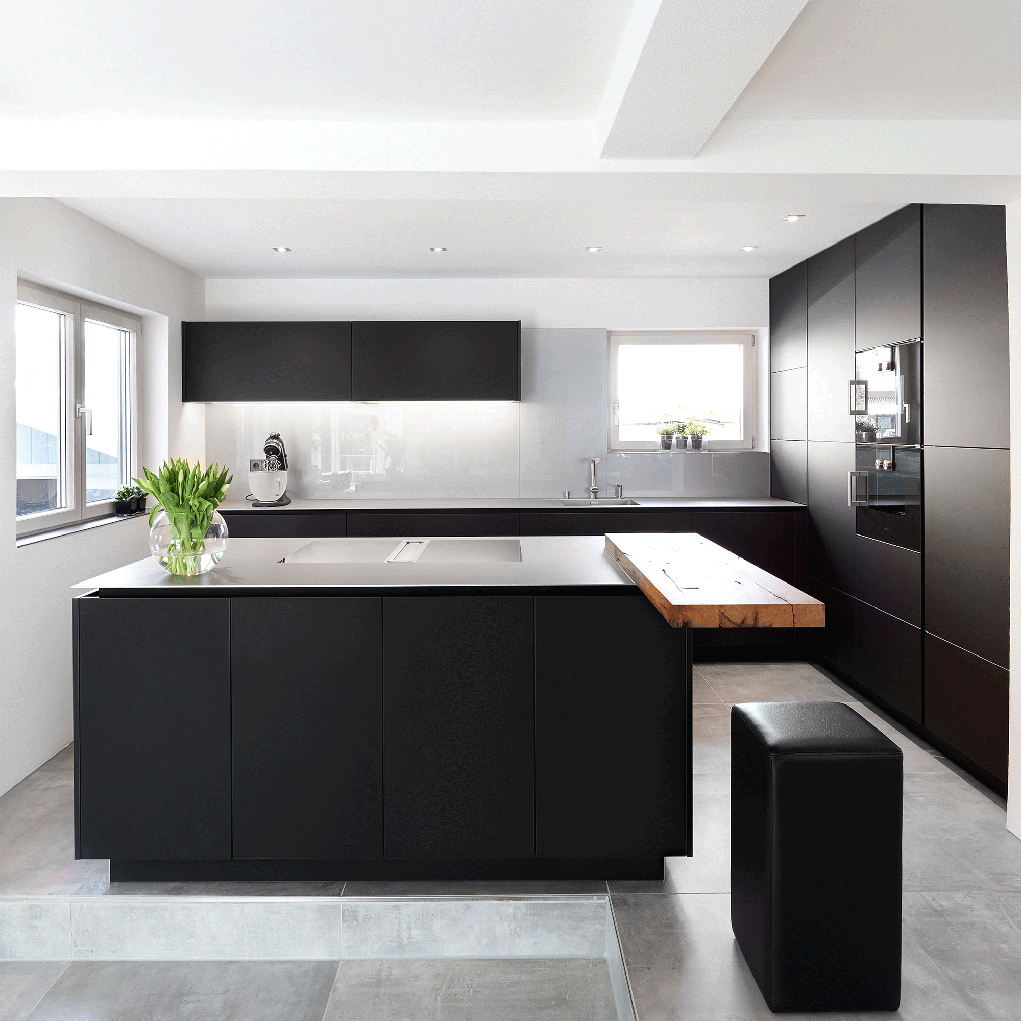 Dark kitchen with a perched wooden counter on the island