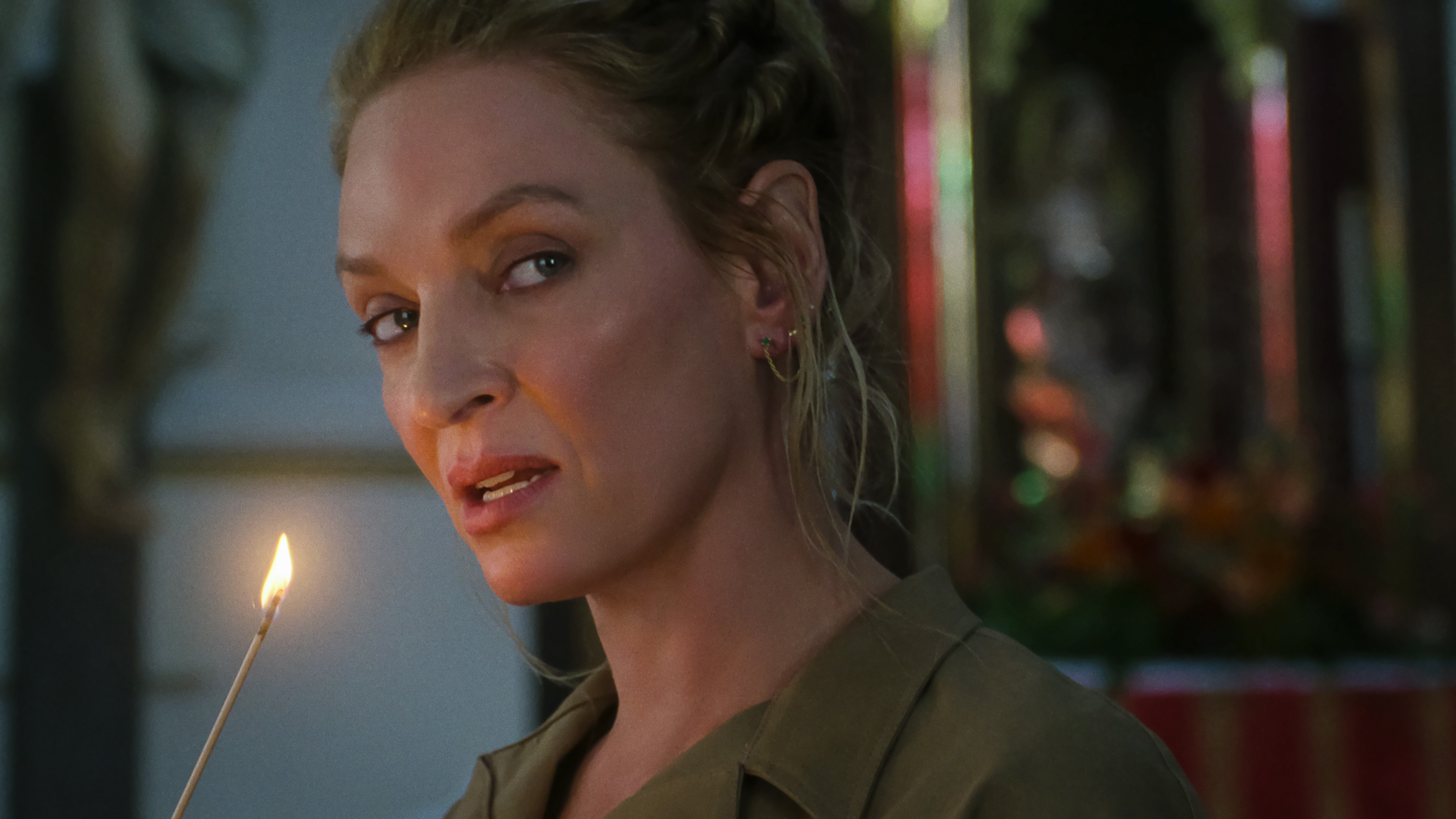 Discord (Uma Thurman) holding a lit matchstick in a scene from "The Old Guard 2"