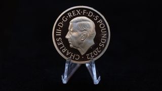 A five pound commemorative crown piece coin featuring the head of King Charles III displayed by the Royal Mint in London