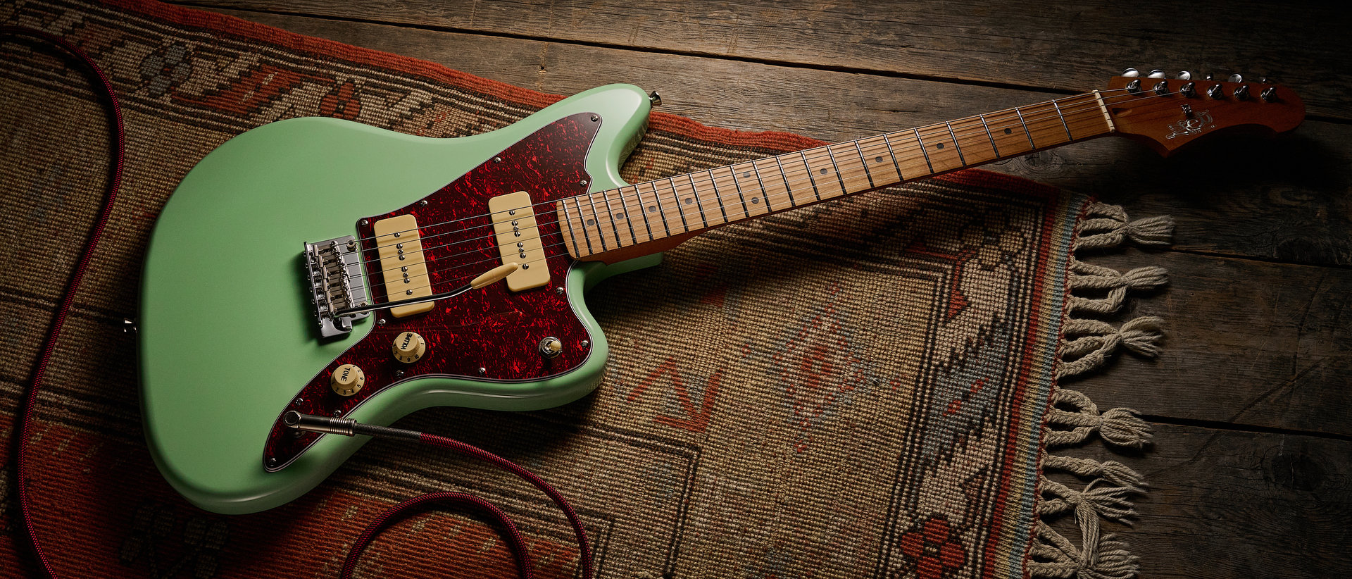 A Jet JJ-300 P90 offset guitar lying on a rug
