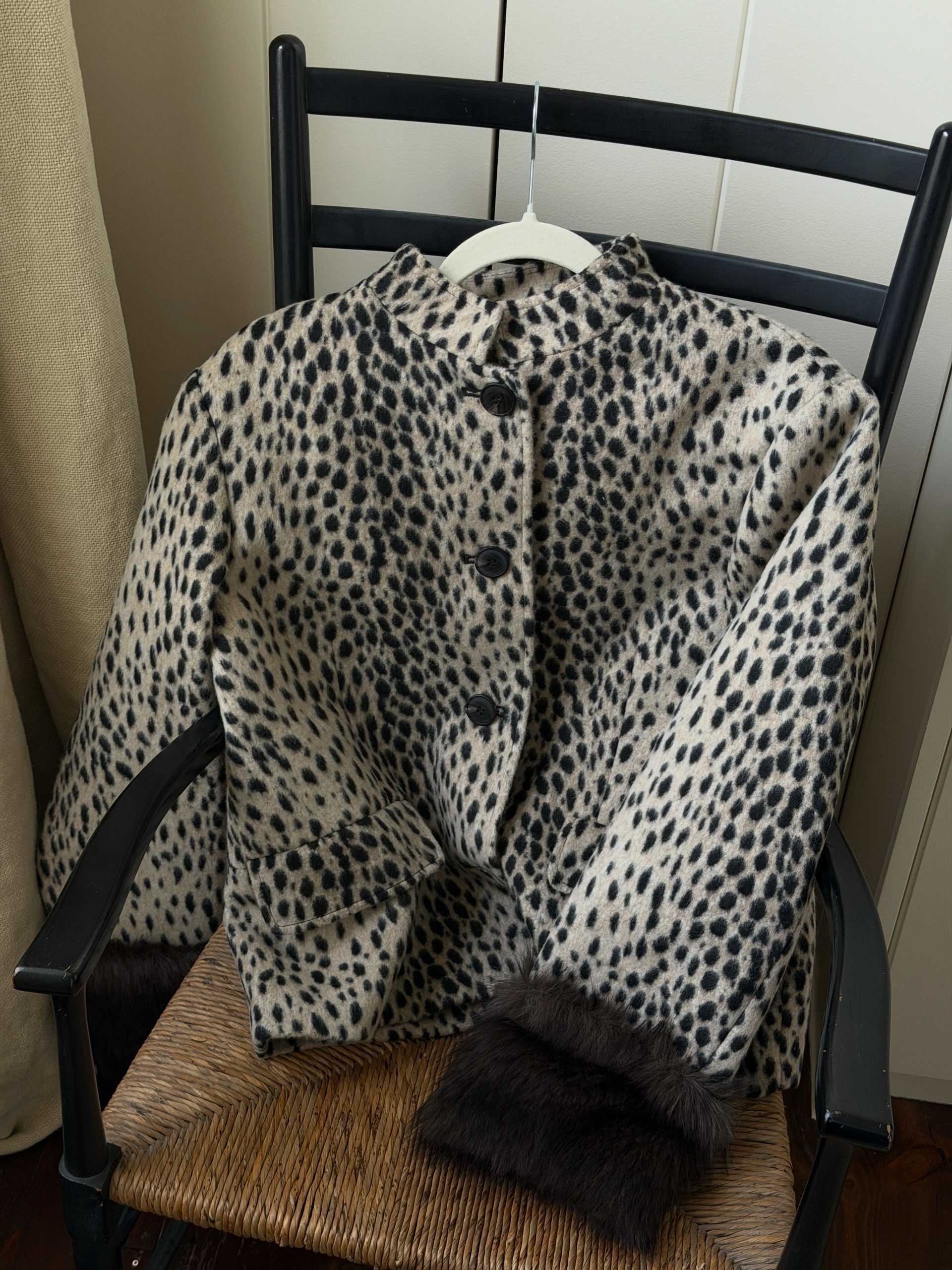 @india.cardona showcases M&amp;amp;S's sold out leopard print, faux-fur jacket on a rattan chair