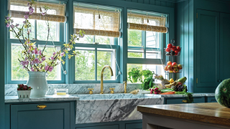 smoky blue country kitchen with a marble sink and wooden island. the ceiling is slatted wood, painted white