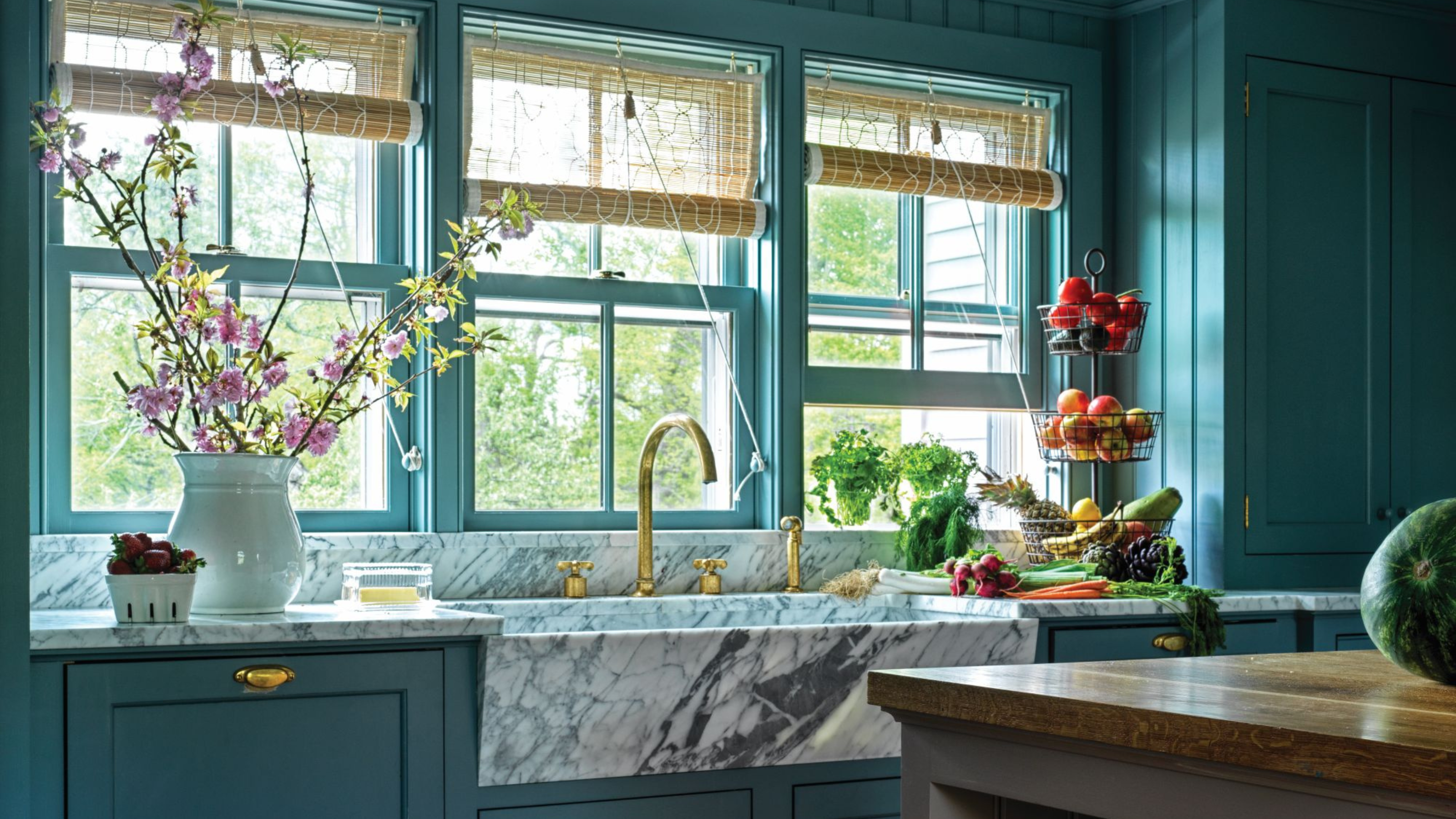 smoky blue country kitchen with a marble sink and wooden island. the ceiling is slatted wood, painted white