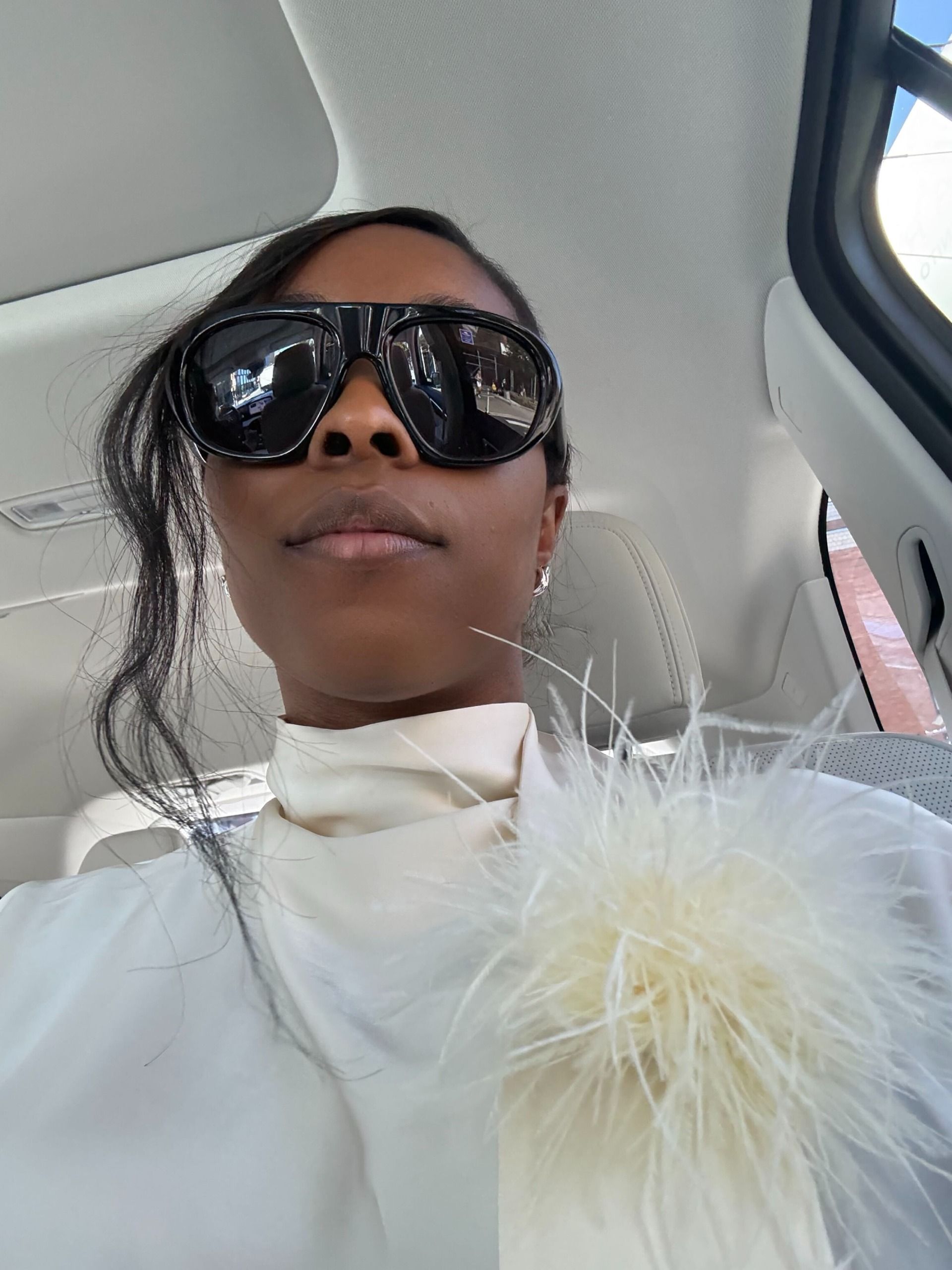 cortne bonilla wearing a white feathered brooch