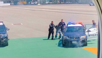A man has been arrested after doing push-ups on a runway at LAX airport