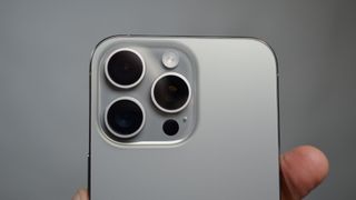 Apple iPhone 15 Pro Maxin takakamera harmaalla taustalla