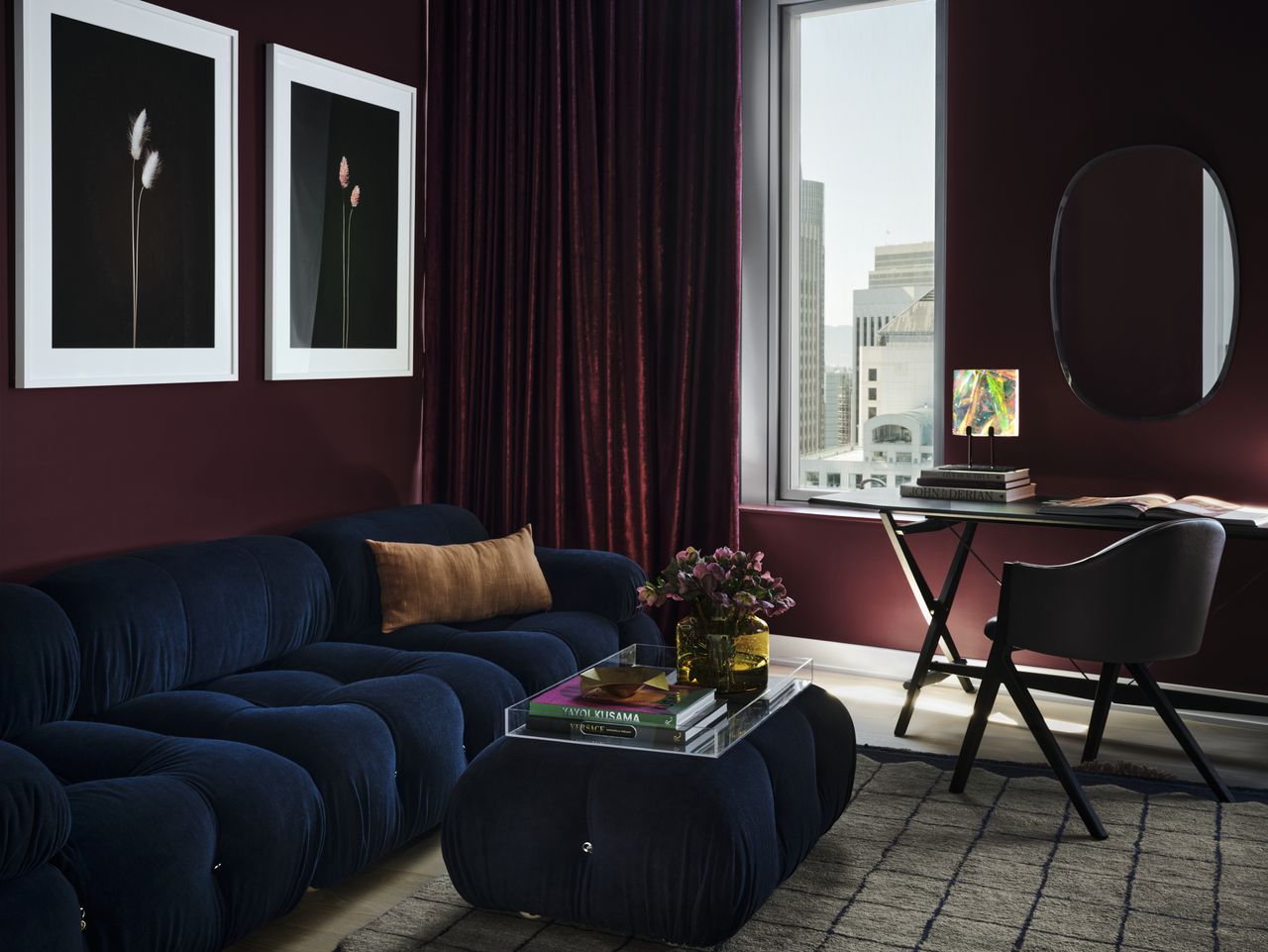 A living room with a deep blue sofa and purple walls