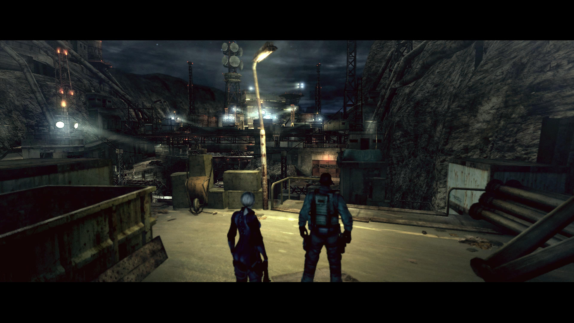 Jill and Chris look out across an Umbrella compound in high alert in Resident Evil 5's Desperate Struggle DLC
