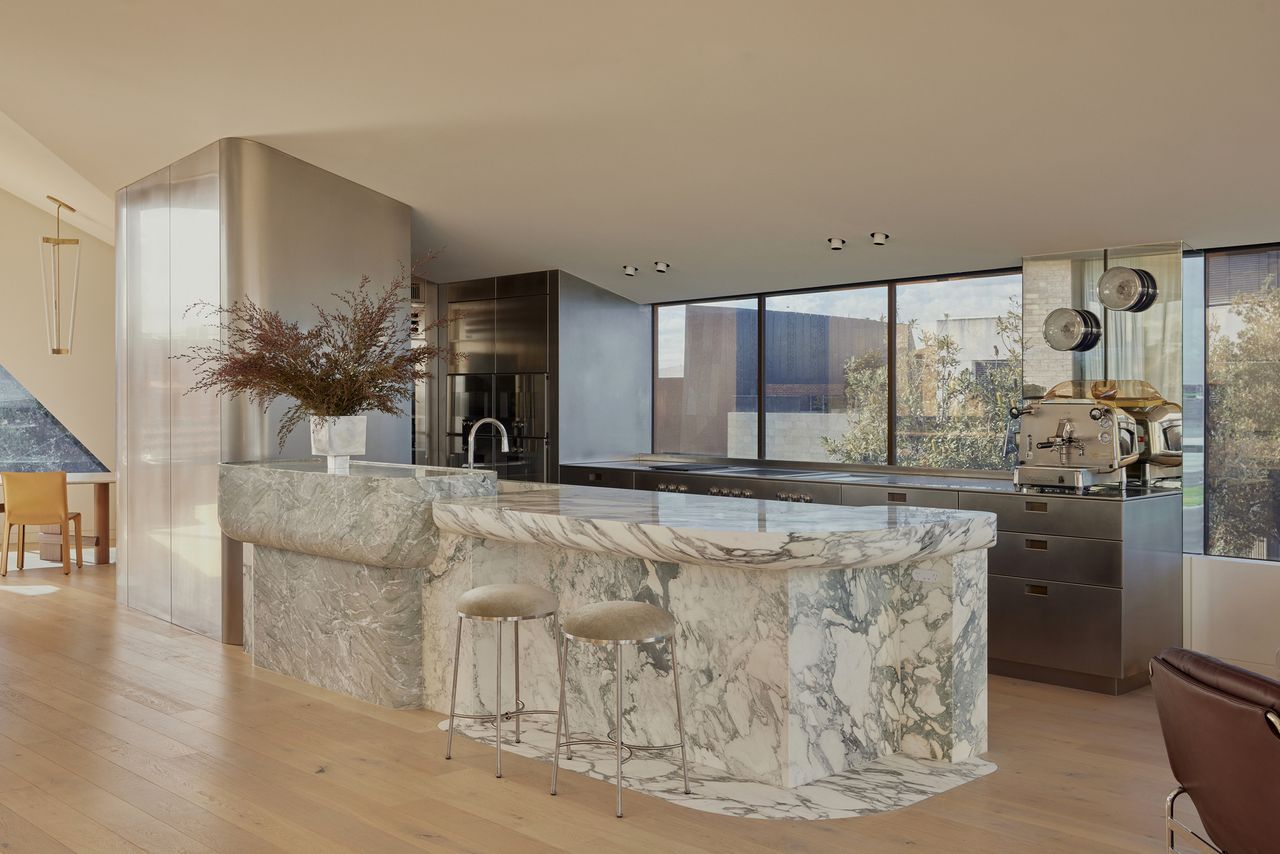 modern kitchen with marble island with sloped ceiling, stainless joinery, coffee machine