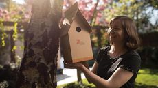 Woman with a cardboard bird box