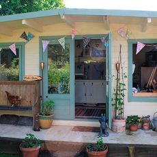 wooden shed with teal colour door pots