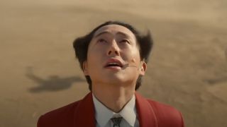 Steven Yeun staring up at doom in Nope