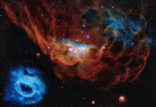 Happy birthday, Hubble! To celebrate the 30th anniversary of the launch of the Hubble Space Telescope, NASA released this new image of a "cosmic undersea world" that is teeming with stars and colorful clouds of interstellar dust and gas. The image features the giant red nebula NGC 2014 and its smaller blue companion NGC 2020, both located in the Large Magellanic Cloud, a small satellite galaxy of the Milky Way located 163,000 light-years from Earth. Hubble scientists have nicknamed the image the "Cosmic Reef," because the large nebula "resembles part of a coral reef floating in a vast sea of stars," Hubble officials said in a statement.