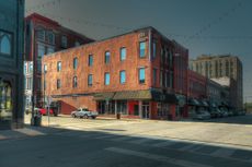 Street corner on a busy street in downtown Springfield, Missouri. A beautiful summer afternoon. Dazzling sunlight and dark shadows dominate the scene.