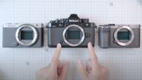 Hands pointing to the Nikon Zf, next to the Lumix S9 and Sony A7C II