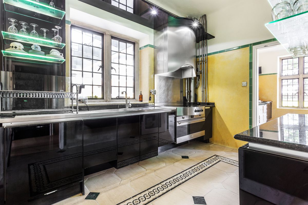 A silver kitchen with ceramic tiled floor