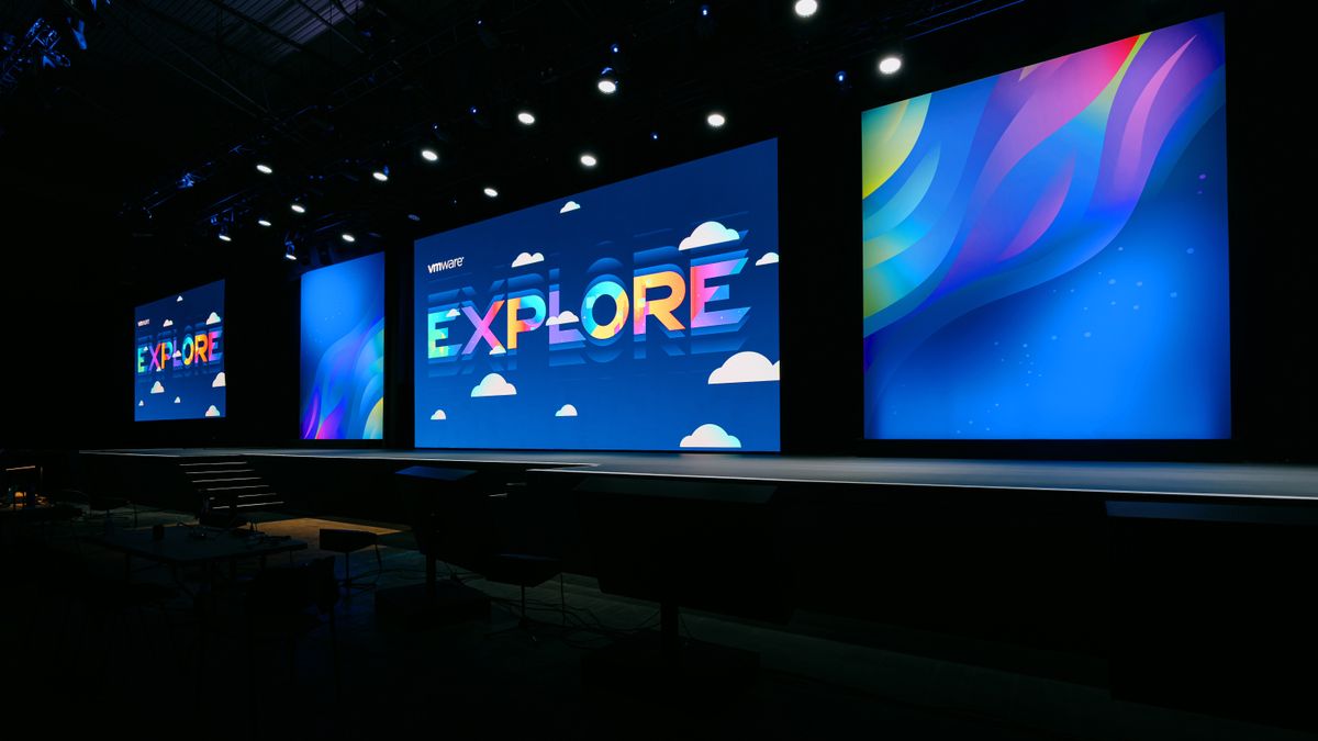 The VMware Explore keynote stage, with large screens bearing the VMware Explore logo.