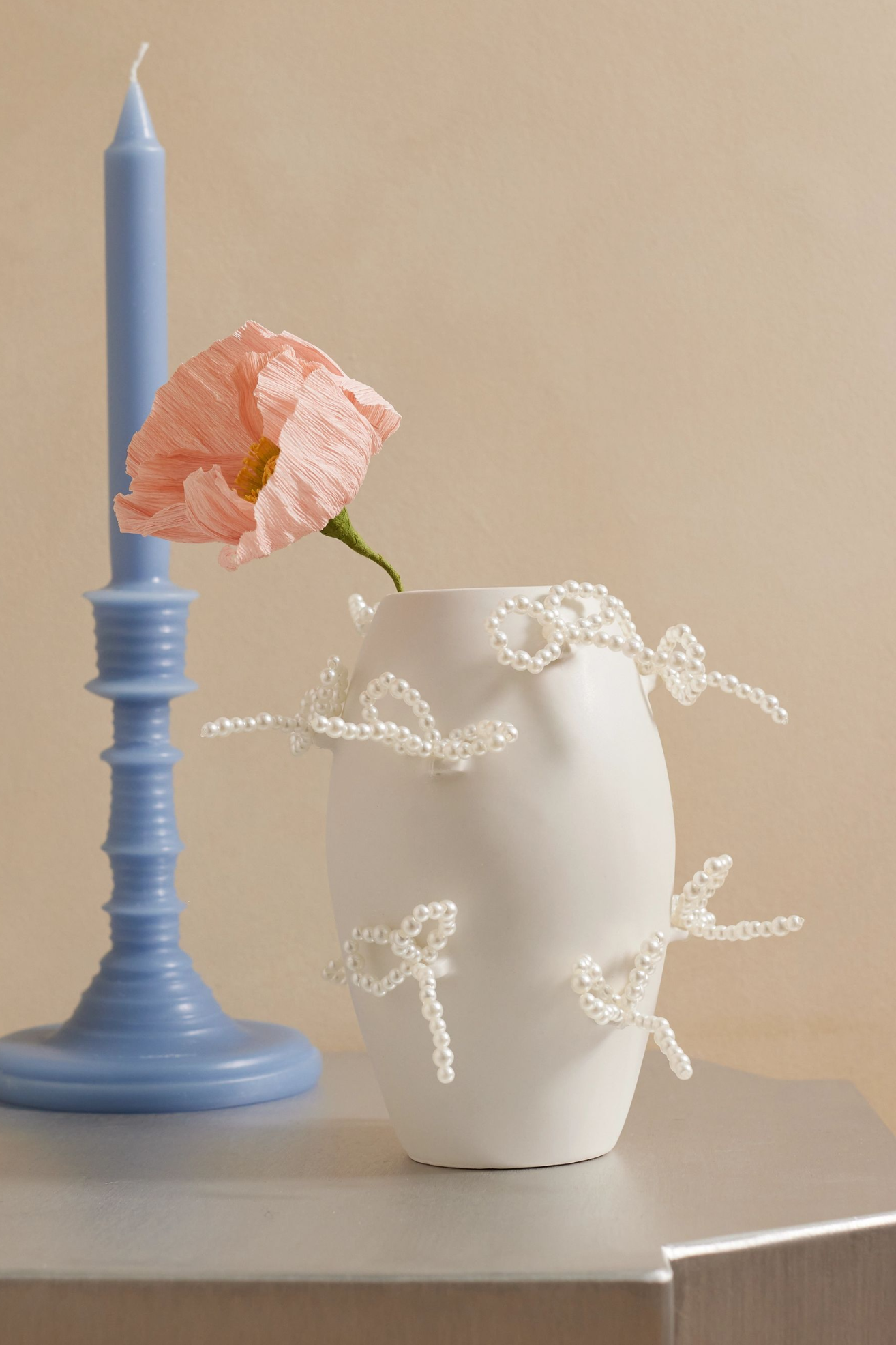 A white vase with pearl bows