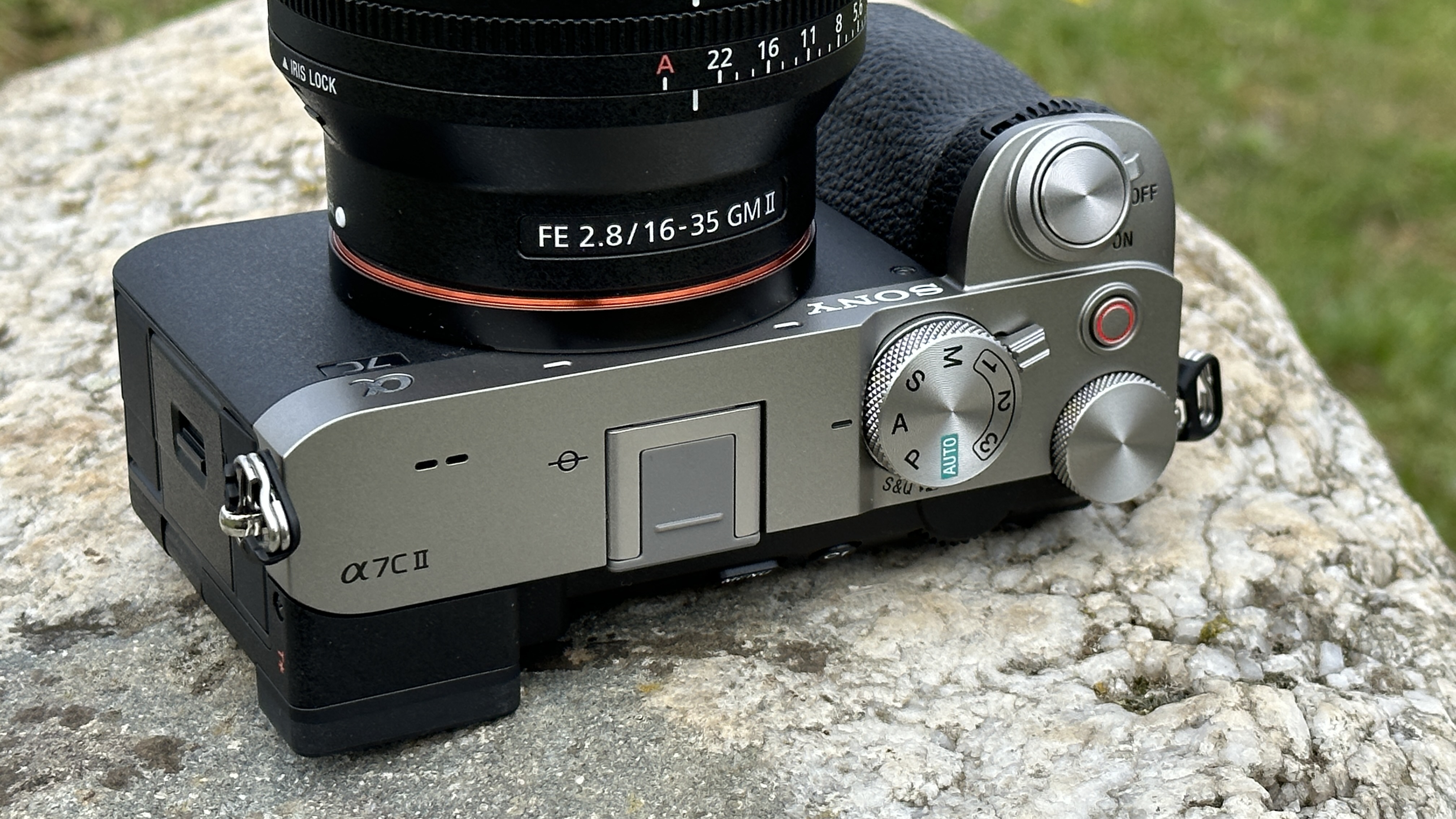 Top plate of Sony A7C II mirrorless camera, outside on a rock with Sony FE 16-35mm F2.8 GM II lens attached