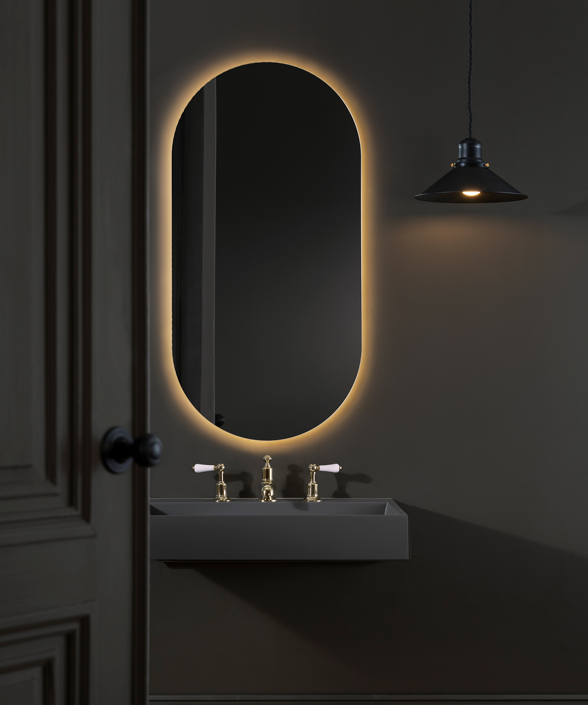 oval illuminated mirror in dark grey bathroom