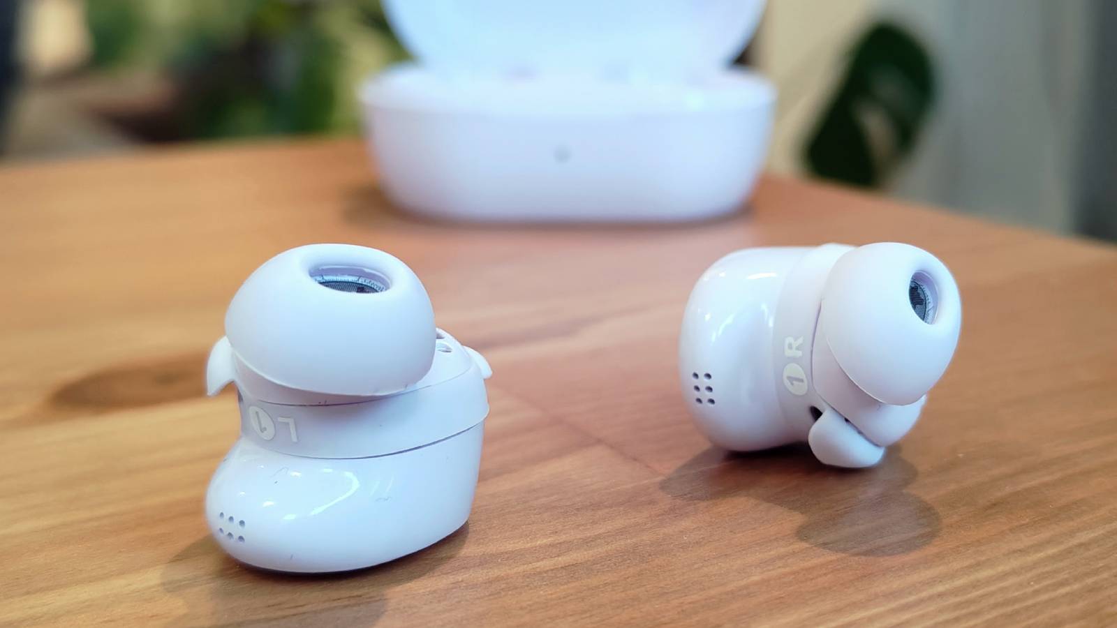 The Bose QuietComfort Earbuds 2024 on a wooden table.