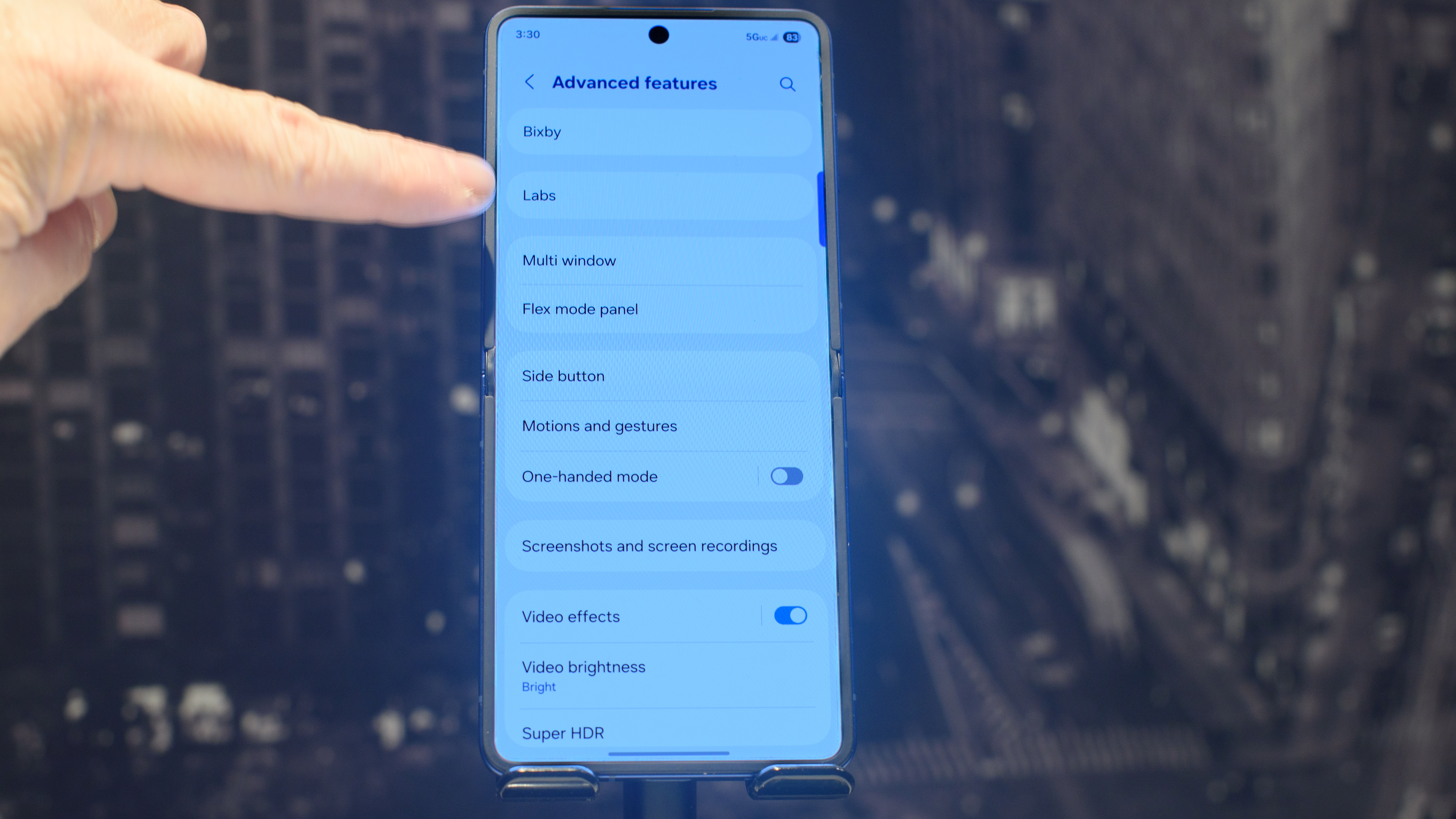 Samsung Galaxy Z Flip 7 in blue with a finger pointing at the Advanced Features Labs setting