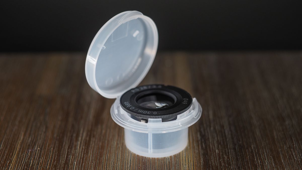 Samyang Remaster Slim lens, with plastic case, on a wooden surface