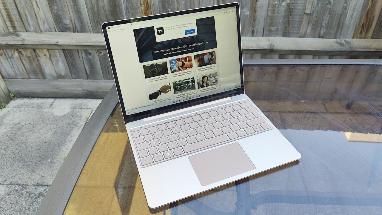 Microsoft Surface Laptop Go 2 review: laptop on garden table by a wooden fence