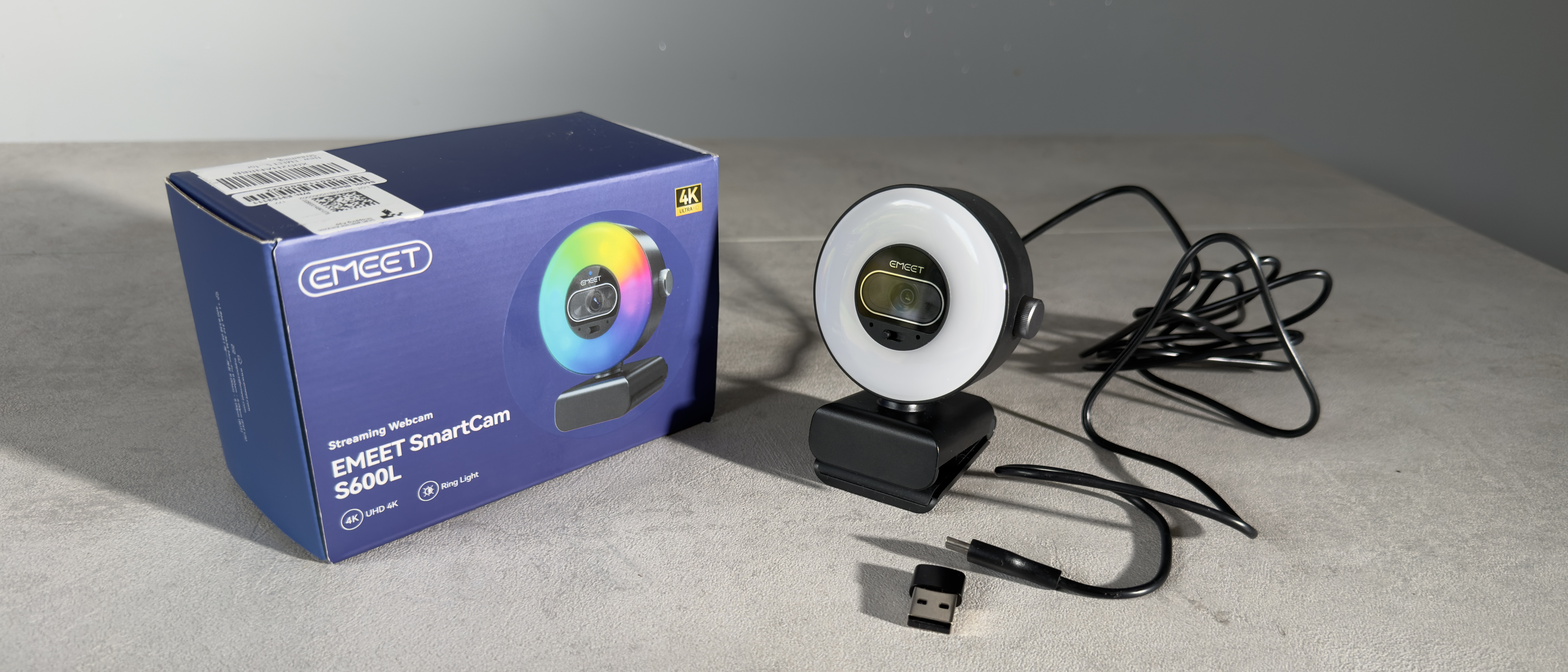 The EMEET SmartCam S600L webcam, USB cable and adapter displayed beside the retail box.