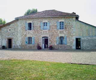 French country house with stone walls and blue shutters