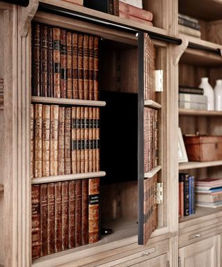 A fake bookshelf that opens as a cupboard to unveil a hidden TV