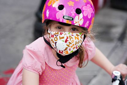 A child wearing a protective mask waits outside Lenox Hill Hospital to show gratitude to the medical staff during the coronavirus pandemic on May 15, 2020 in New York City.