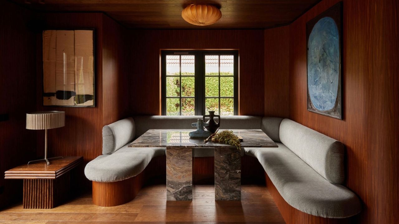 dining room nook with wooden walls and flooring and a marble dining table