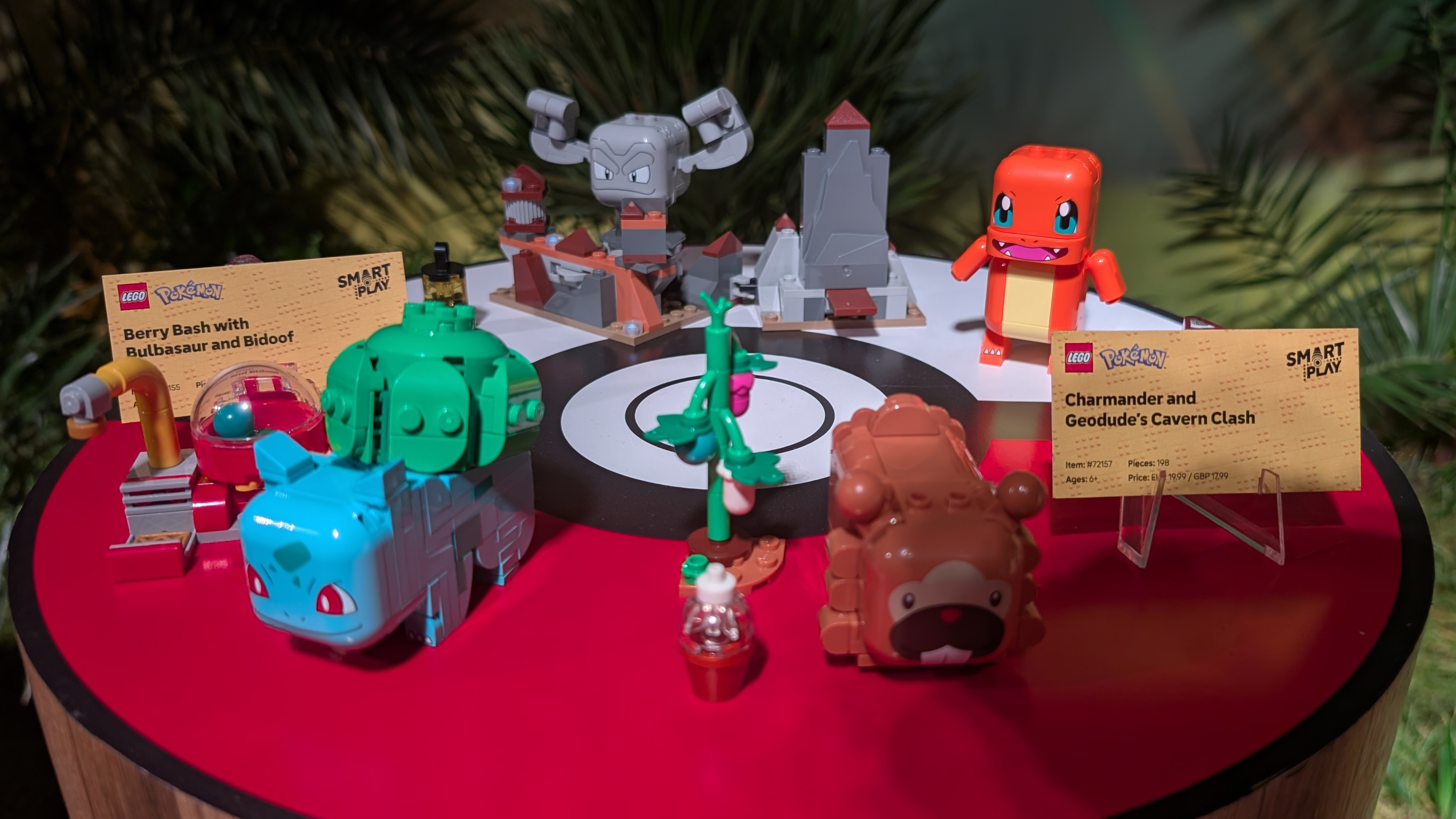 Lego Pokemon on a red and white Poke Ball surface, with cards beside them