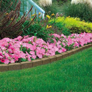 Low maintenance garden ideas: flowerbed edged with recycled pavers