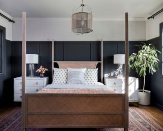 bedroom with dark paneling, cane four poster, white bedside cabinets, patterned rug, throw and cushions