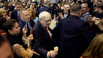 Warren Buffett, CEO of Berkshire Hathaway, surrounded by fans and media