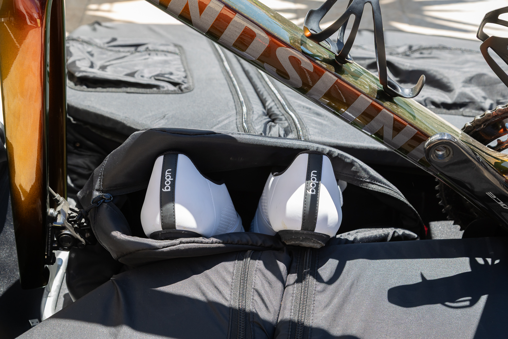 a pair of white shoes sitting in an inside pocket in the bike bag