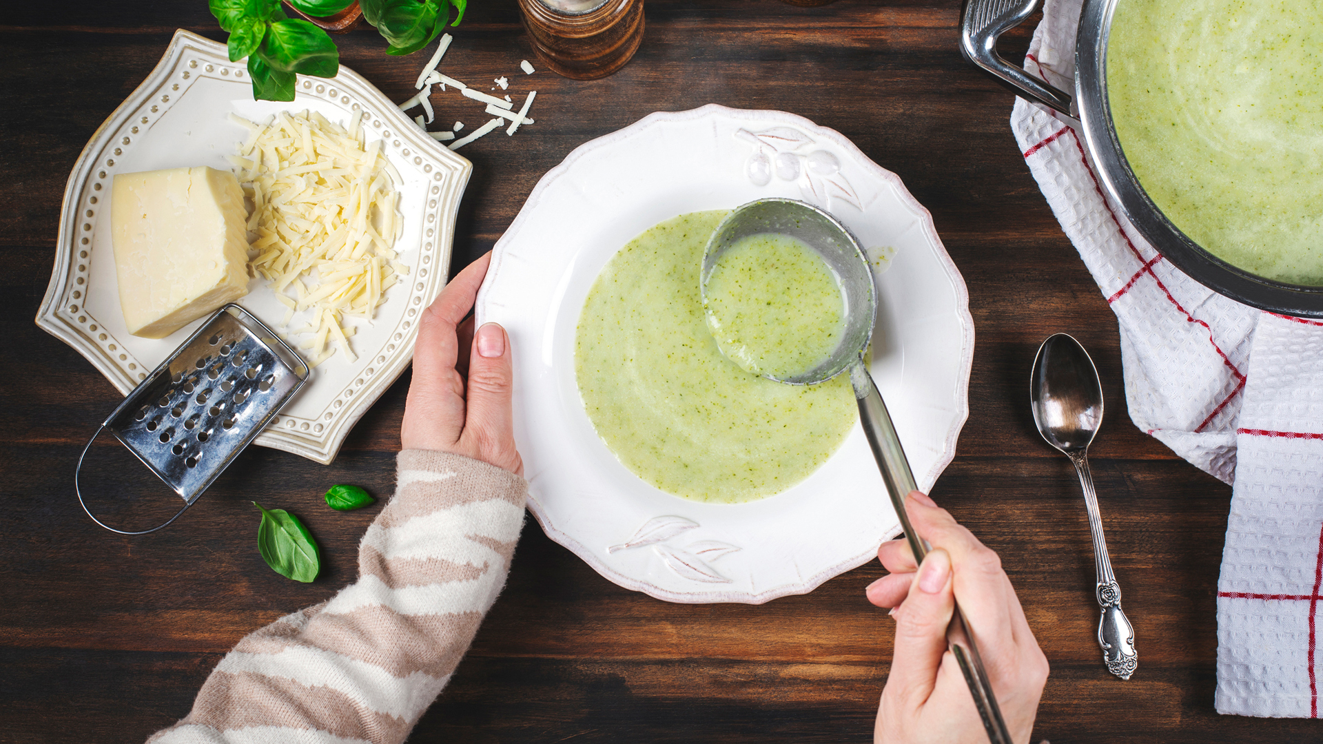 broccoli and cheese soup being ladled into a bowl