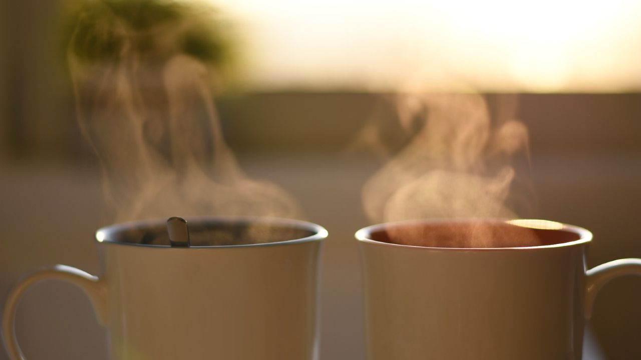 Two cups of hot steaming coffee - stock photo