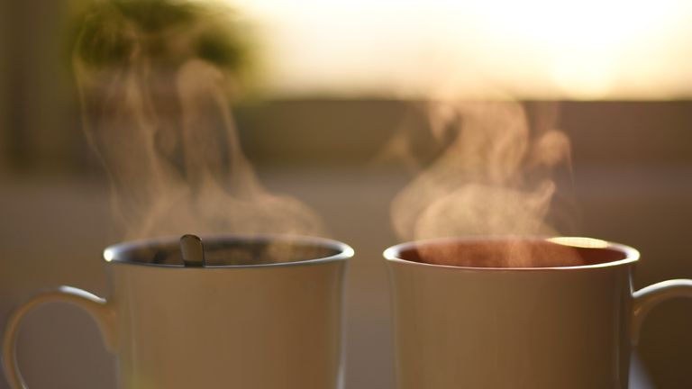 Two cups of hot steaming coffee - stock photo