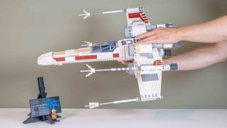 Lego UCS X-Wing Starfighter being held with two hands to show its huge scale
