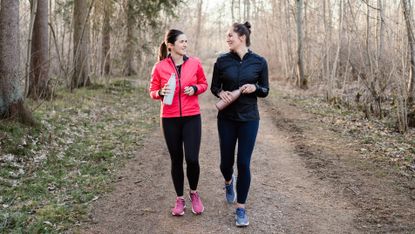 Two women doing walking workout in forest