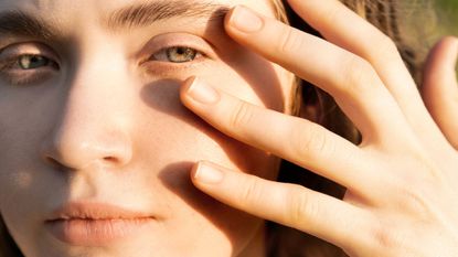 woman touching her eyes - retinol eye cream