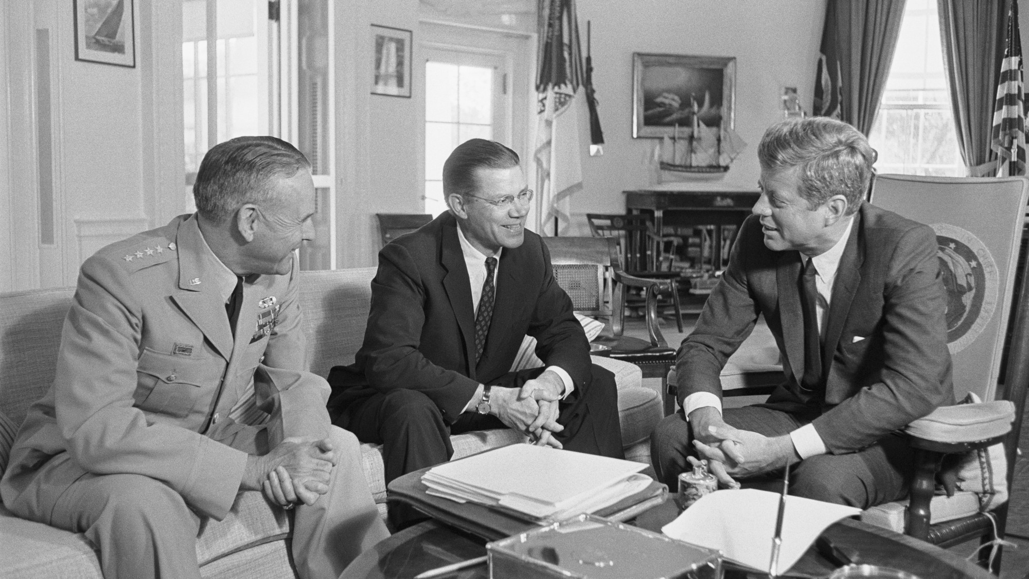 President John F Kennedy confers with Chairman of the Joint Chiefs of Staff, (left) and Defense Secretary Robert McNamara (center)
