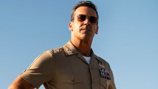 A sunglassed Jon Hamm stands outside in uniform in Top Gun: Maverick.