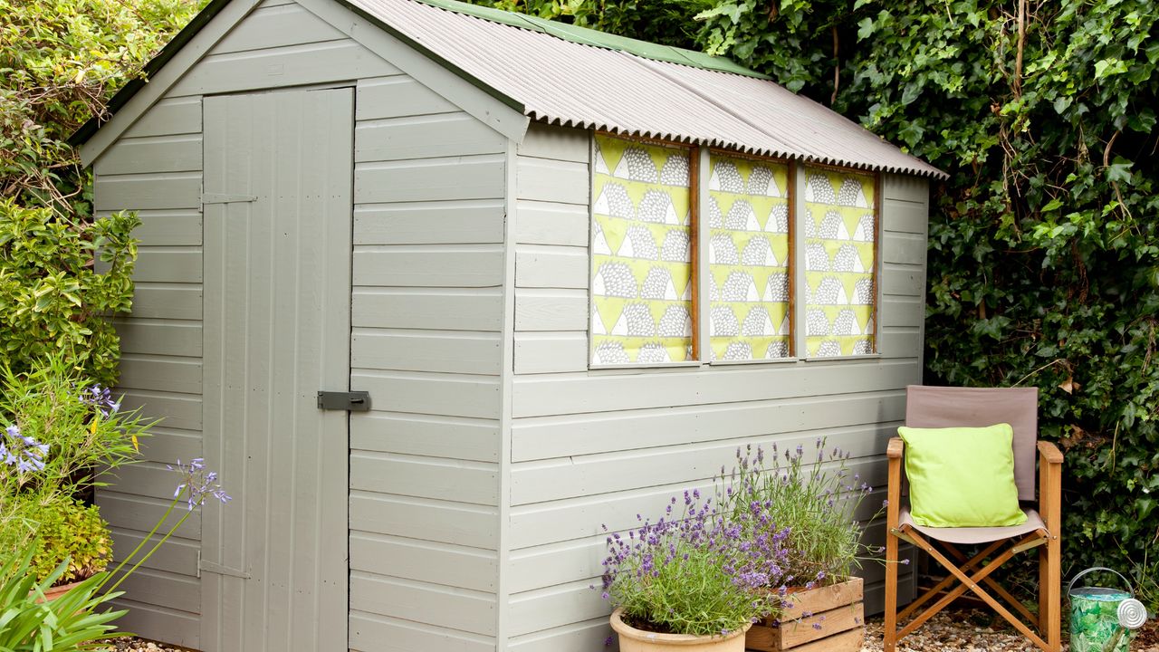 how to organise a shed shed painted blue with dark blue potting table inside and chairs outside