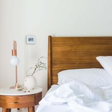 bed with wooden headboard and bedside table