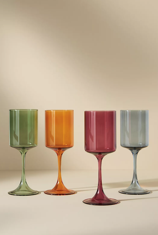 four flat bottom wine glasses in different earthy colors lined up together