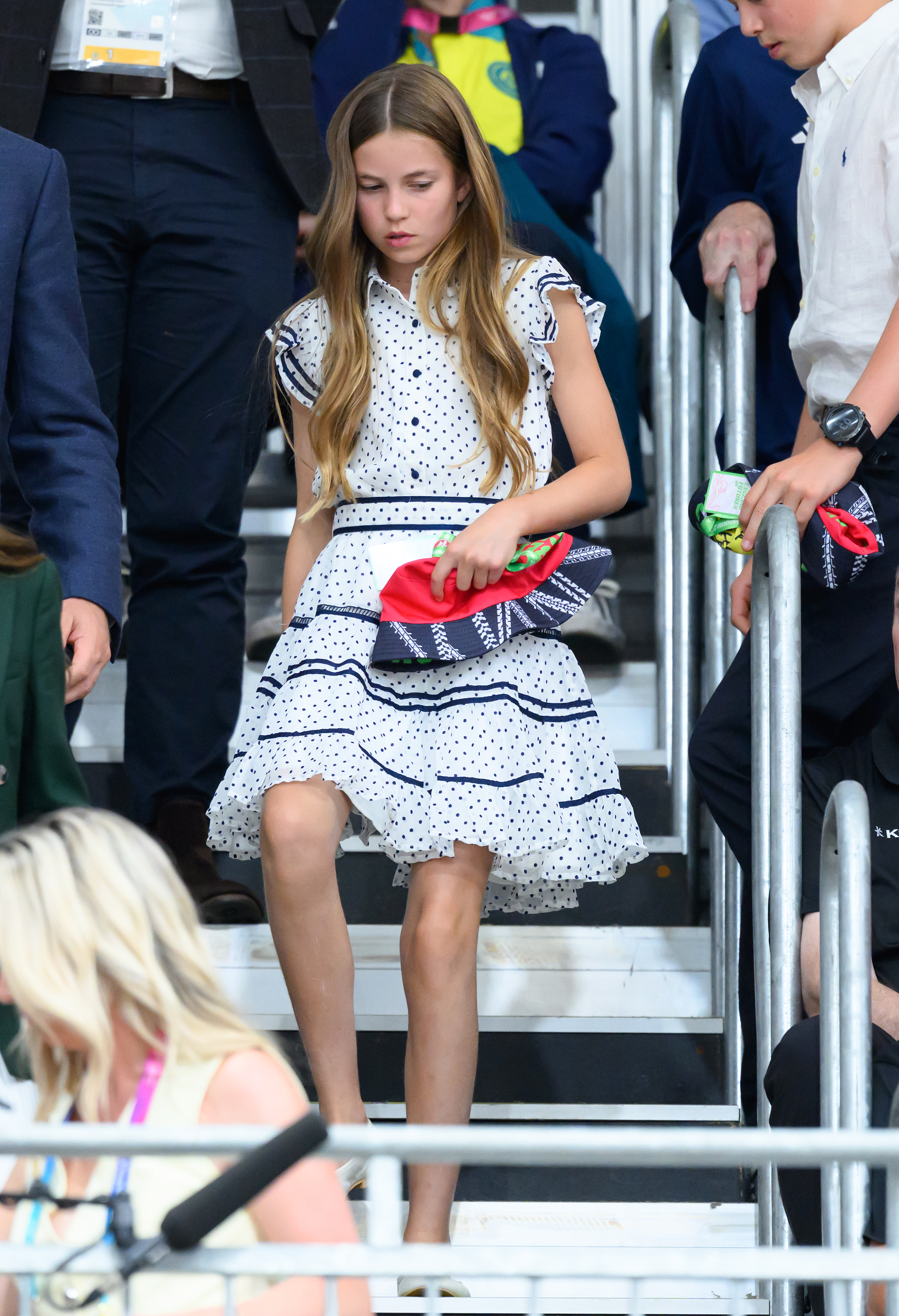 Princess Charlotte wearing a polka dot dress walking down stairs at the Commonwealth Games